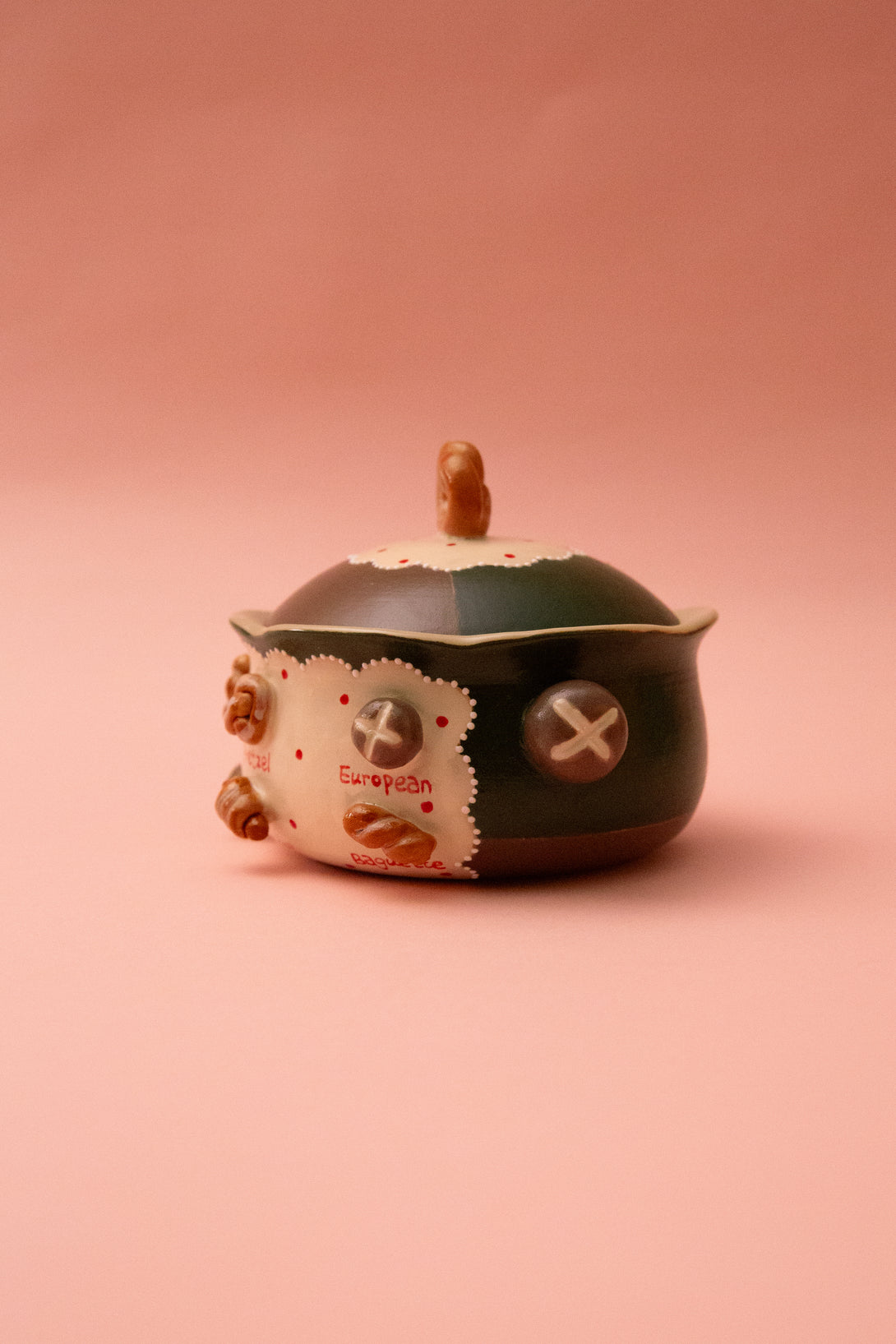 ceramic bowl with lid on a pink background