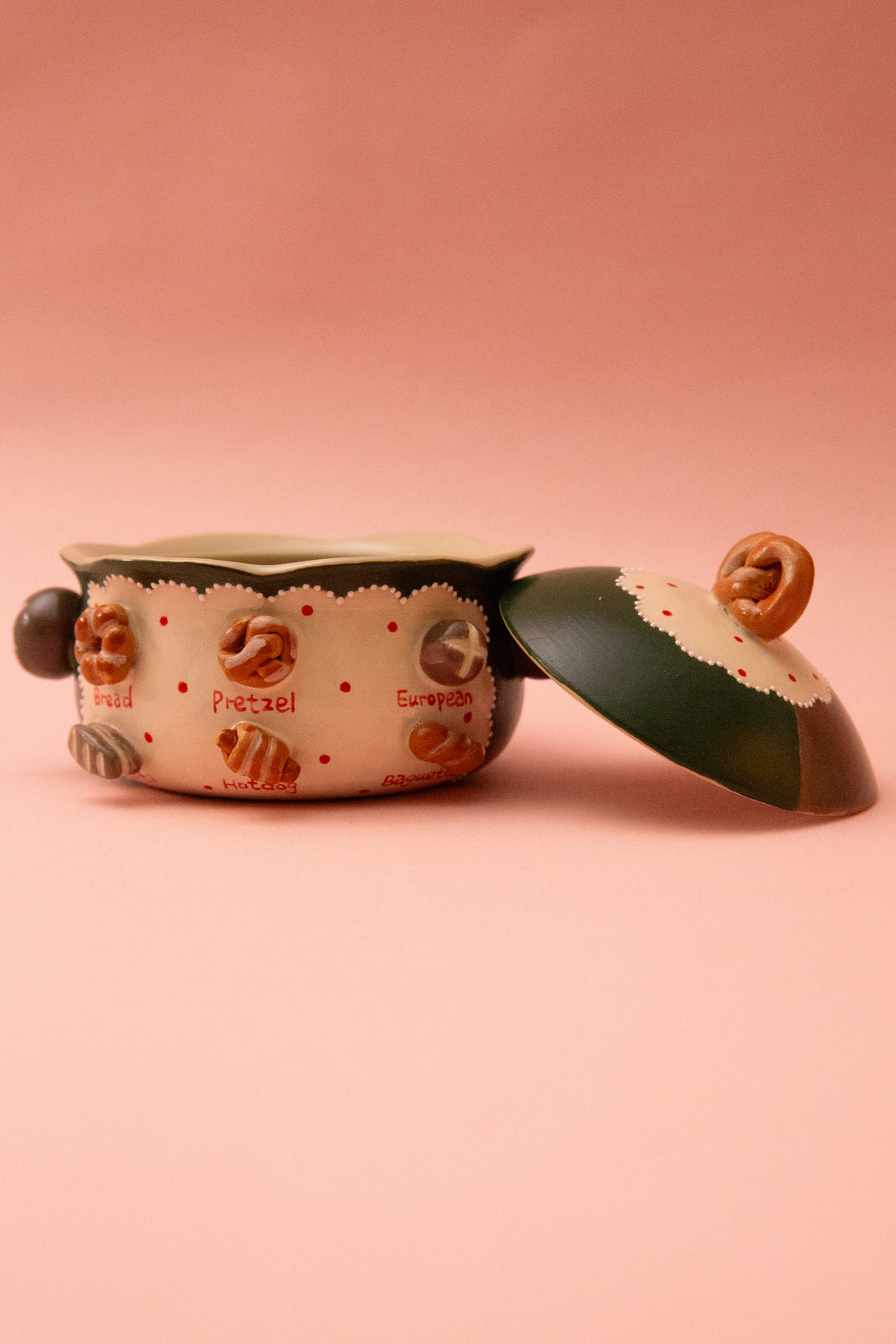 Ceramic bowl with a lid on a pink background