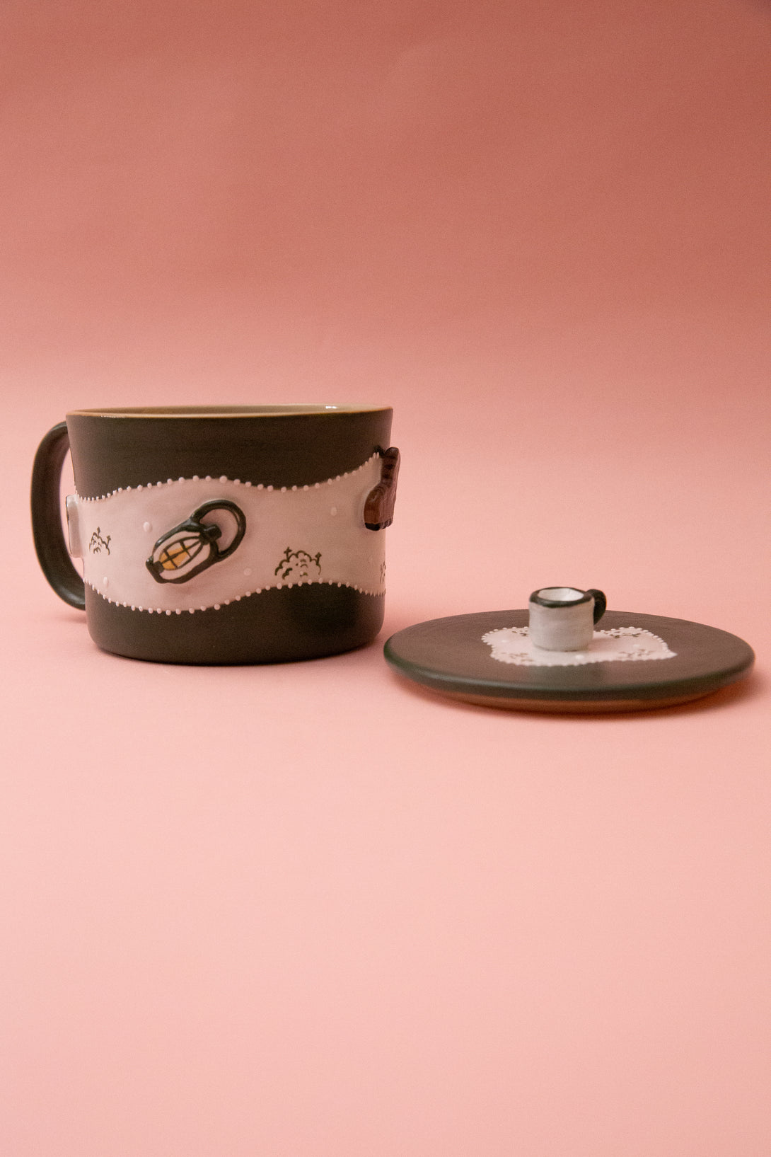 Ceramic mug with decorative elements on a pink background