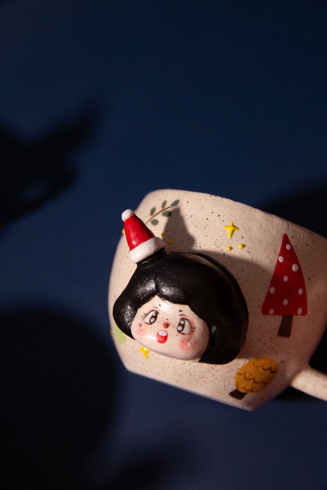 Christmas mug with a face design and Christmas-themed elements on a dark background