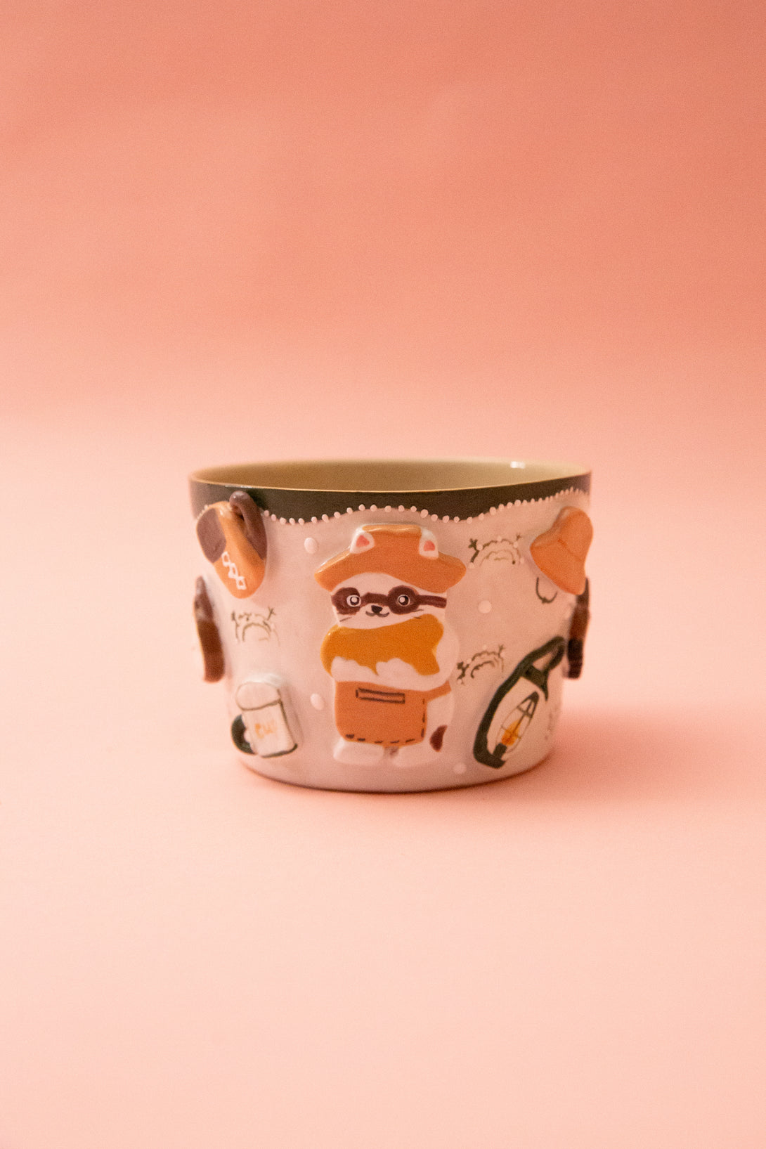 Ceramic mug with racoon design on a pink background