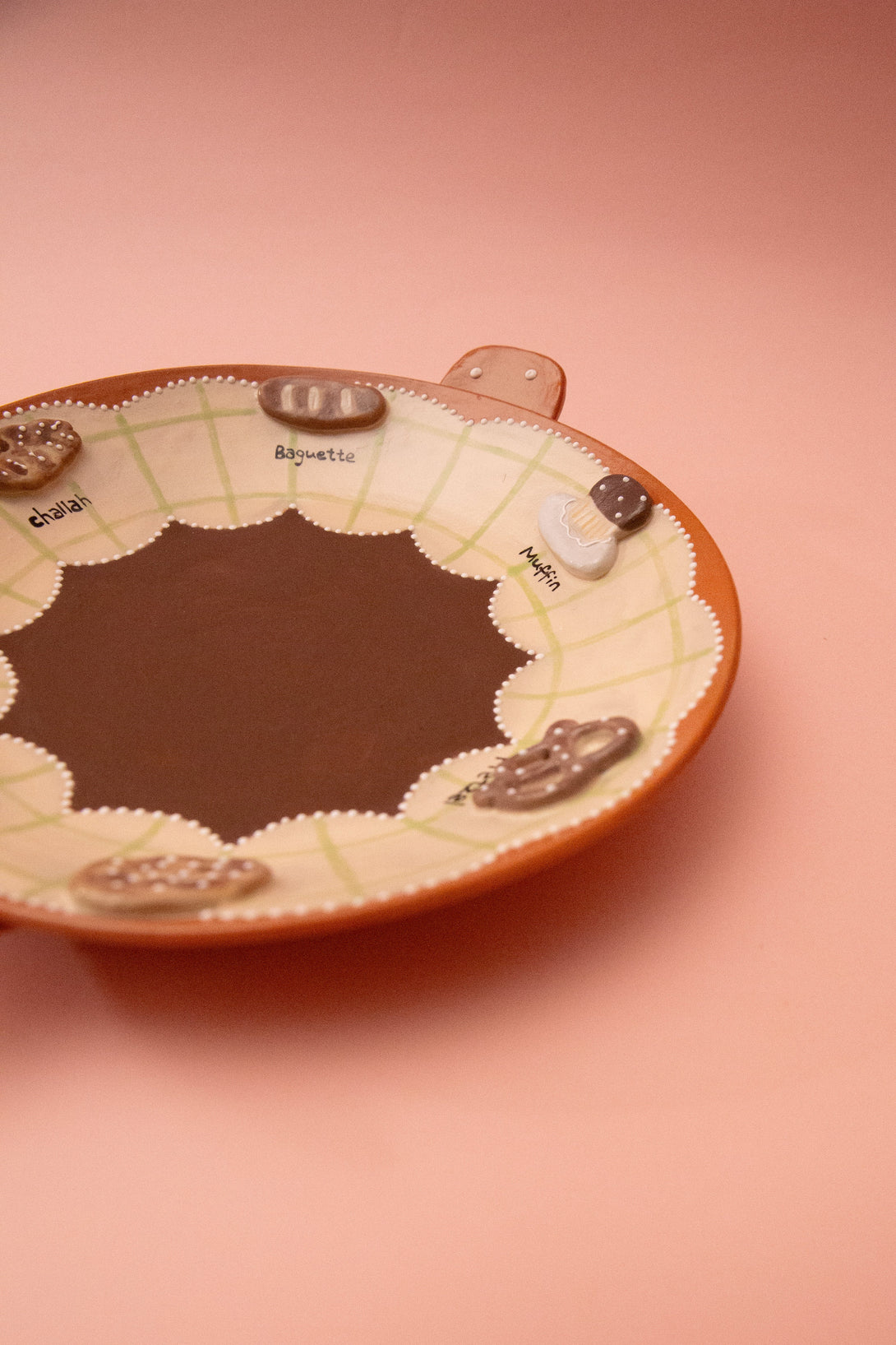 ceramic plate with a bread themed design on a pink background