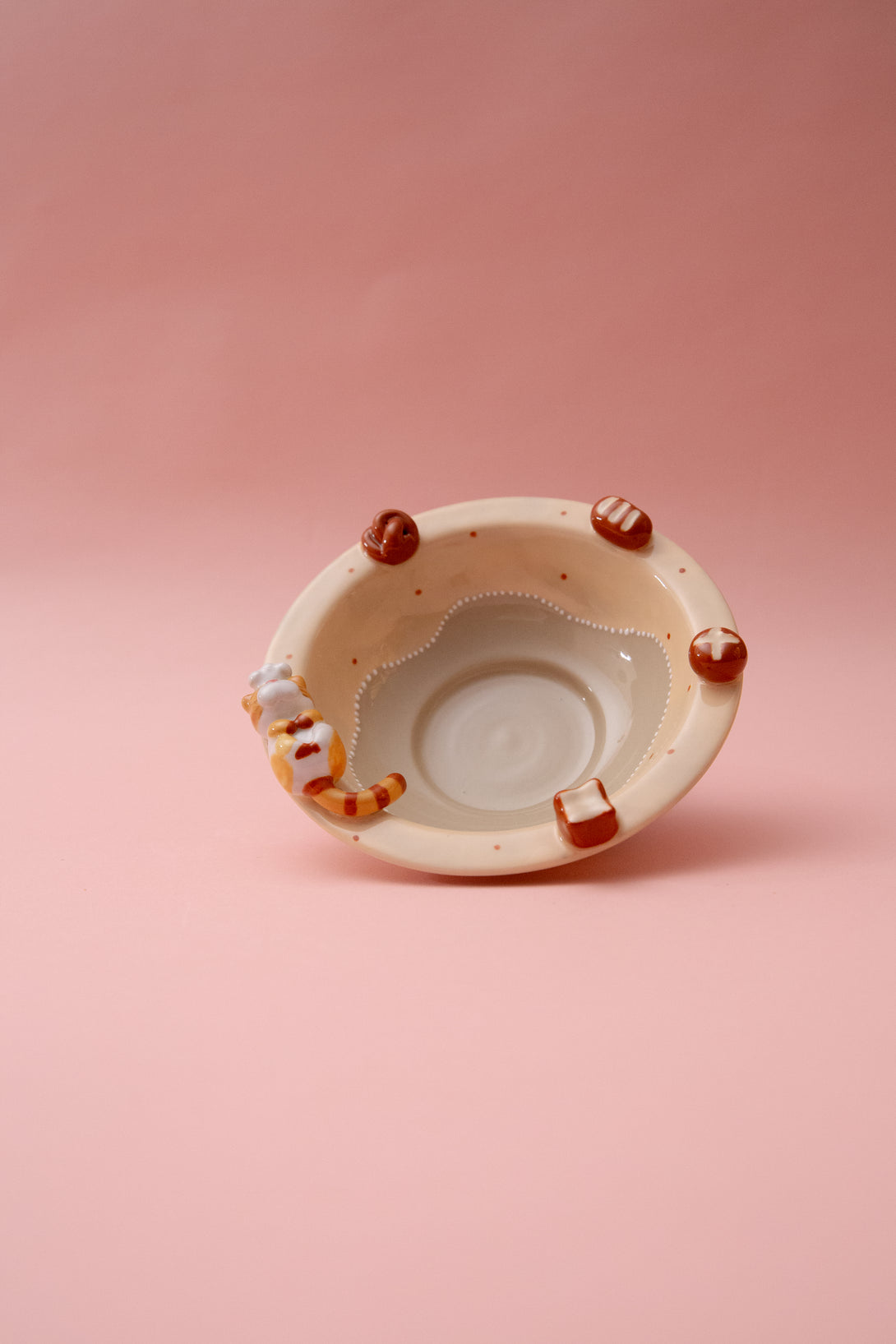 Ceramic bowl with decorative elements on a pink background