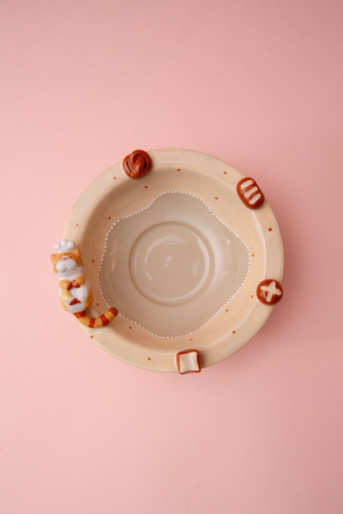 ceramic bowl with small figurines on a pink background