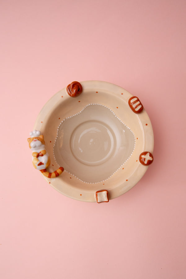 ceramic bowl with small figurines on a pink background