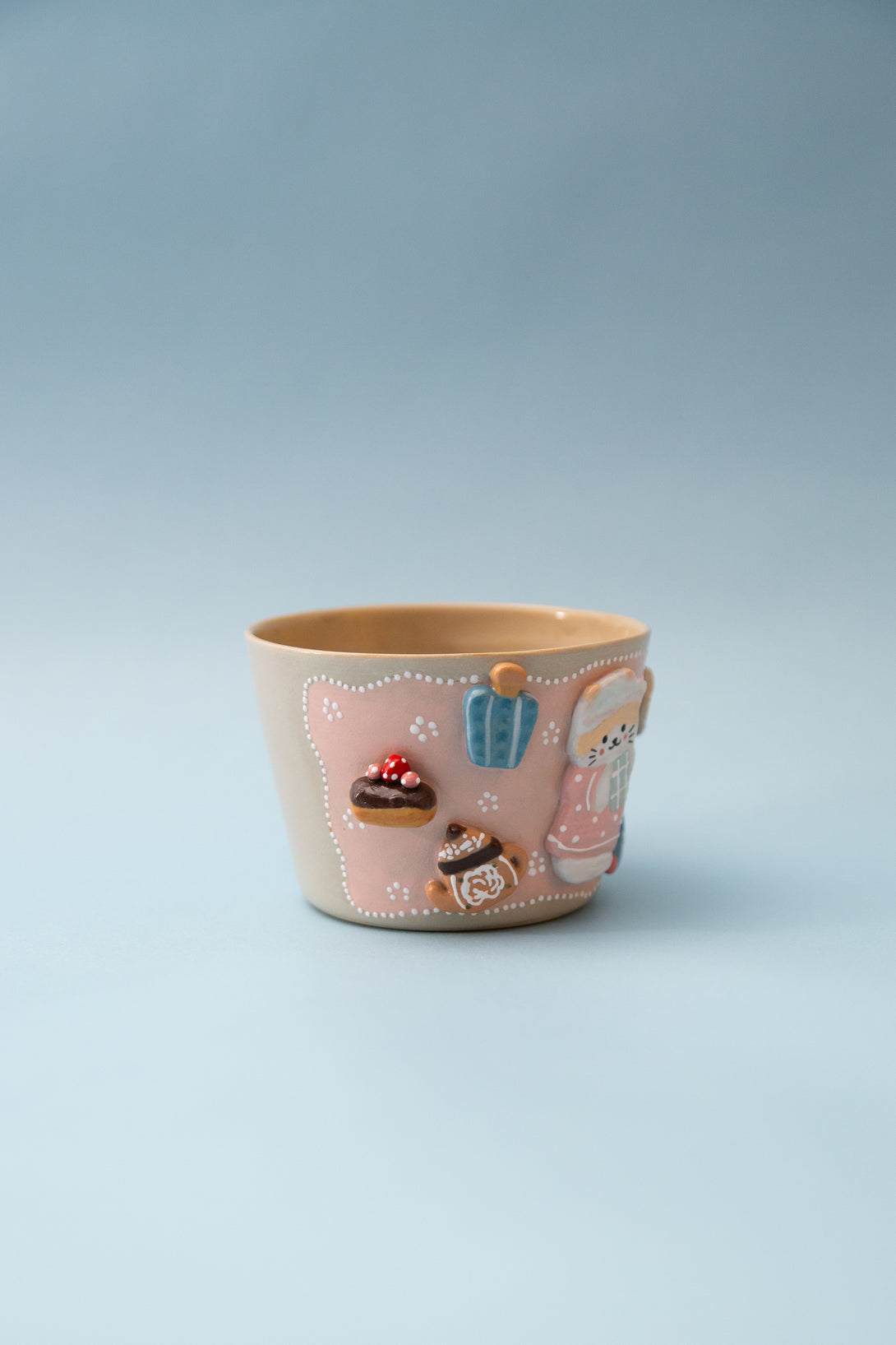 Ceramic cup with cartoon characters and designs on a light blue background