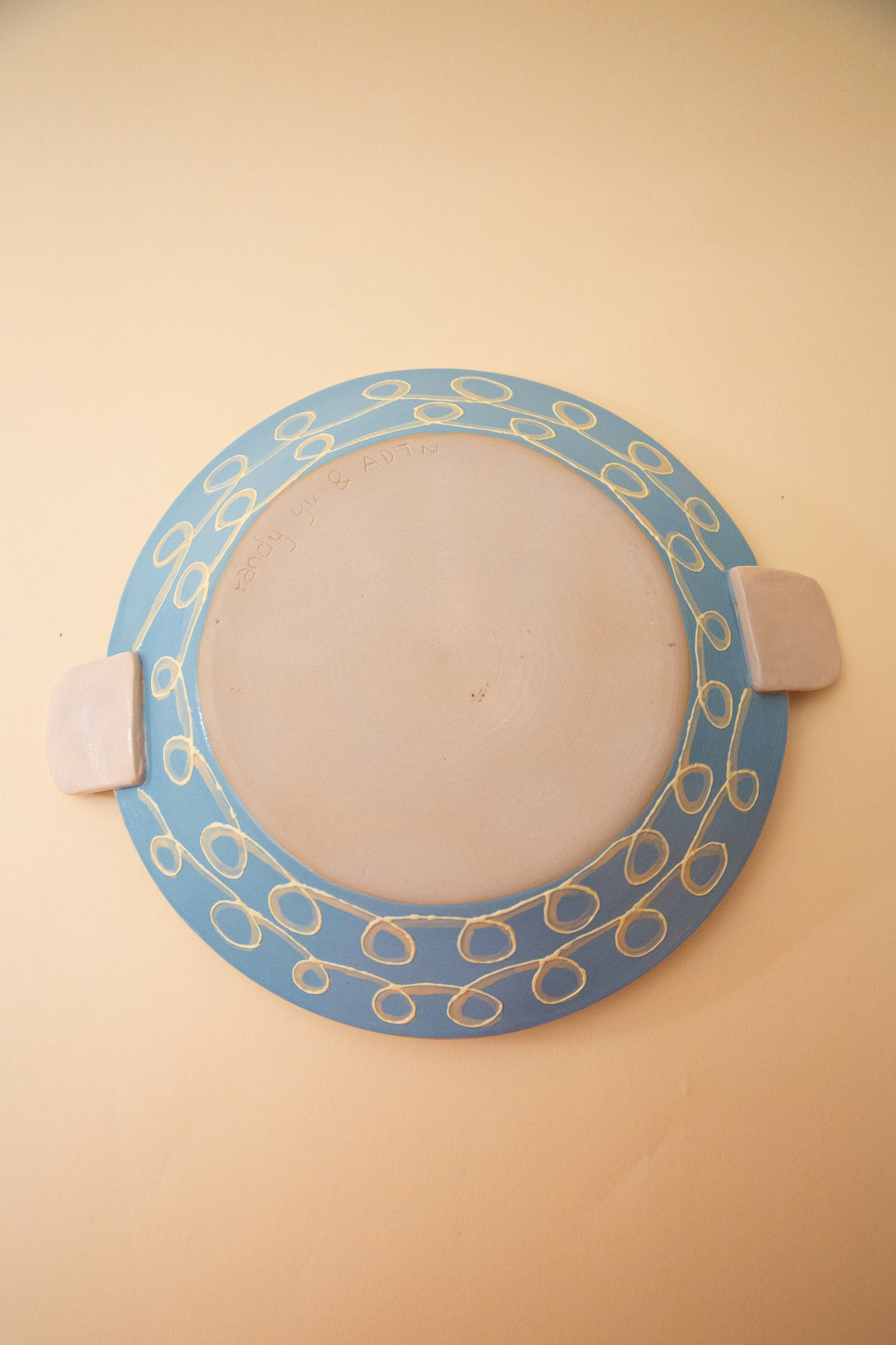 ceramic plate with blue and gold design on a beige background