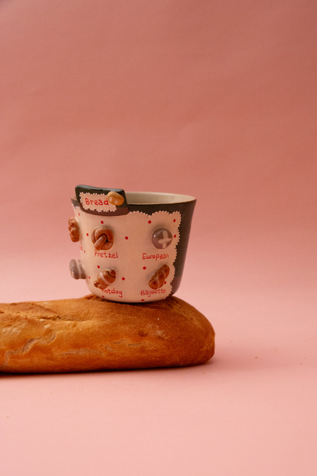 Ceramic mug with bread design on a pink background