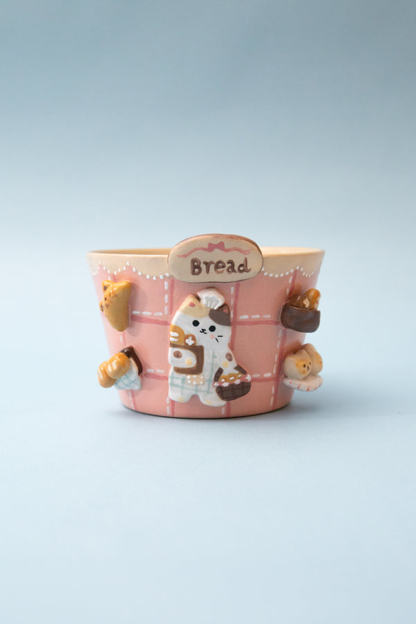 Pink bread themed mug with cartoon character and 'Bread' label on a light blue background