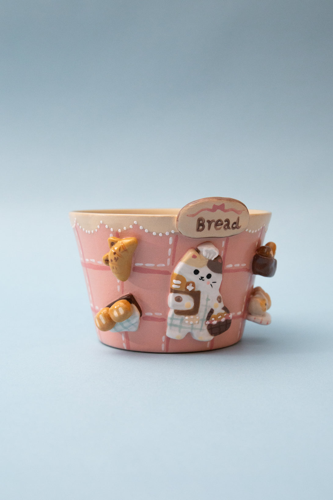 Ceramic bread-themed mug with a cartoon character on a light blue background