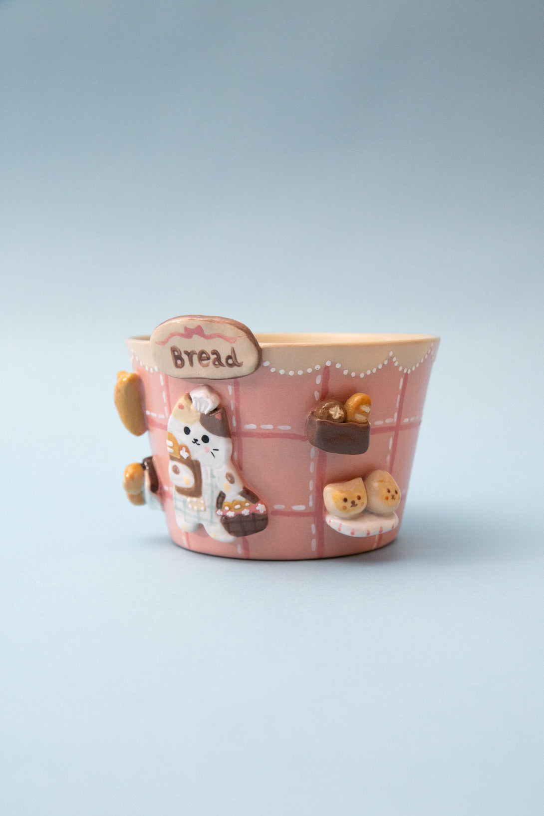 Pink bread-themed mug with cartoon characters on a light blue background