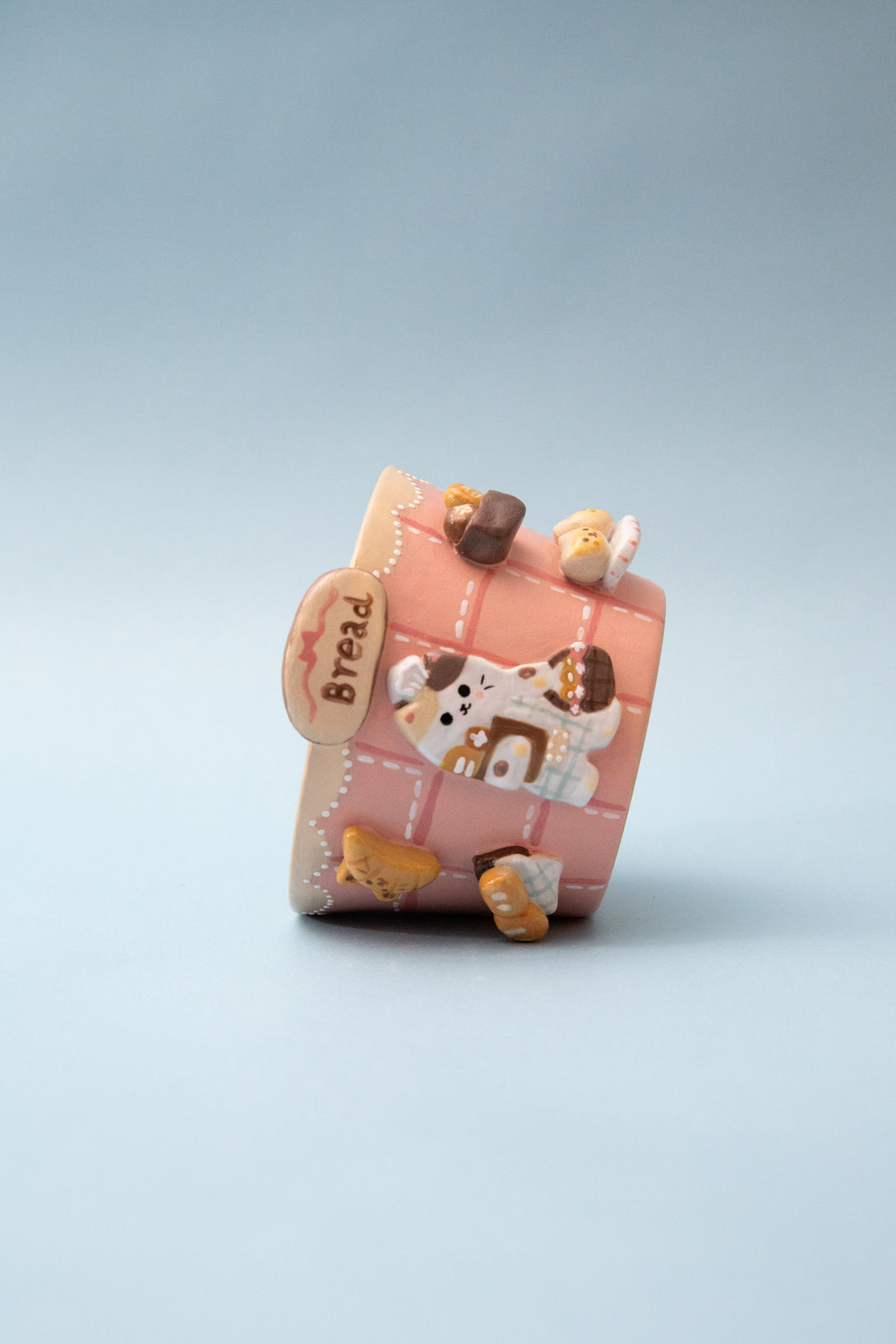 Pink bread themed mug with cartoon cat design on a light blue background