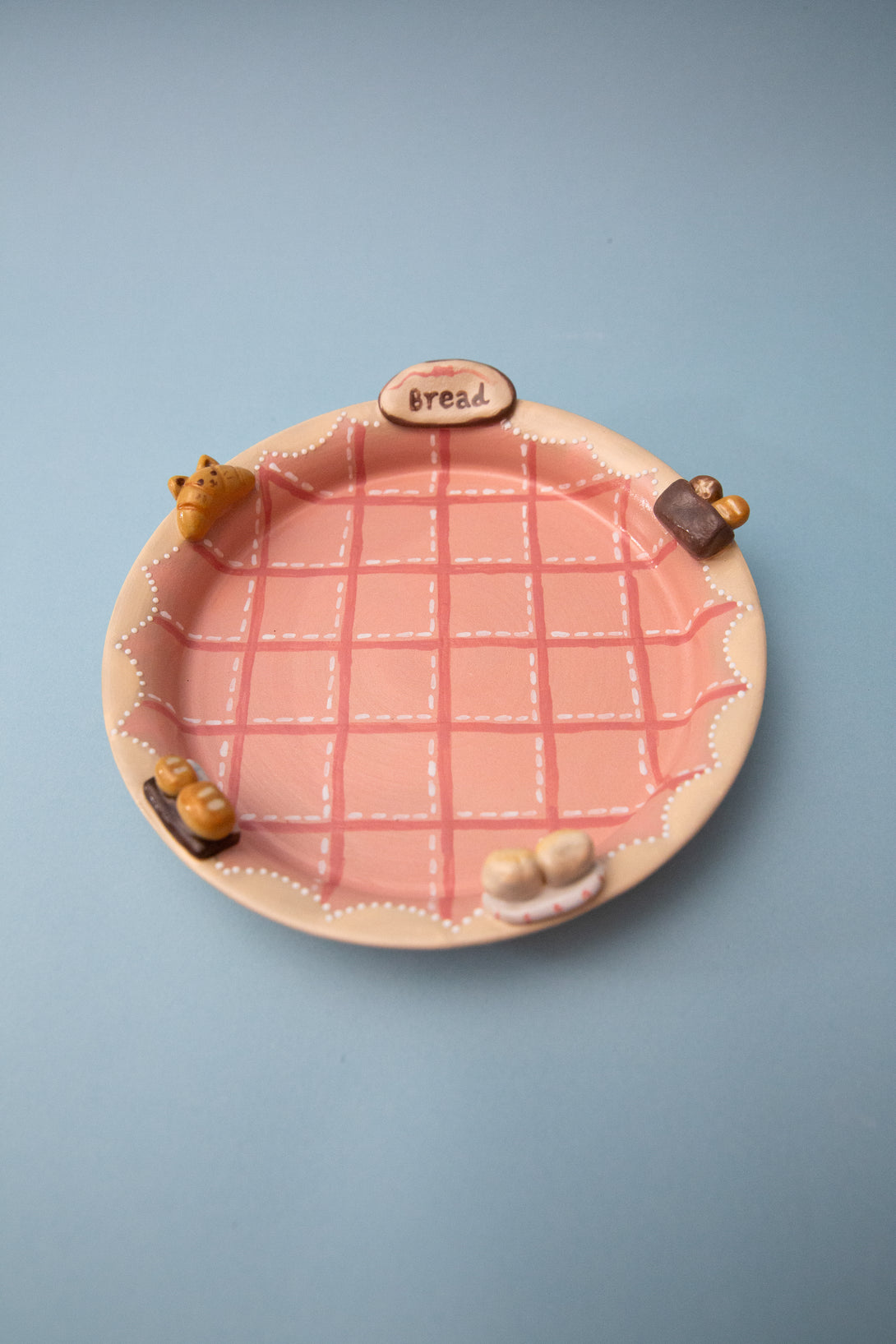 Ceramic pie dish with a pink grid pattern on a blue background